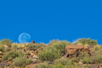 Bright moon rising above in the blue sky in High Atlas Mountains in Morocco