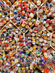 Various buttons for clothes in plastic containers on shelves of sewing store. 
