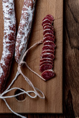 Fuet, a traditional Spanish sausage with rosemary. Slice sausages. Rosemary. Top view. Free space for your text.