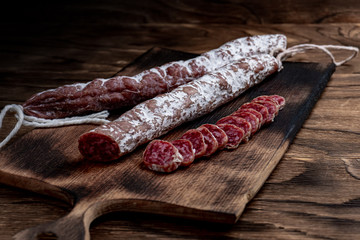 Fuet, a traditional Spanish sausage with rosemary. Slice sausages. Rosemary. Top view. Free space for your text.