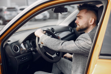 Man buying the car. Businessman in a car salon