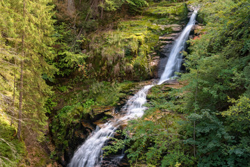 Fototapeta na wymiar Blurred water of waterfall of Kamienczyk river in Poland