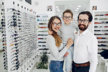 Mother with cute son. Family buy glasses. Father in a white shirt