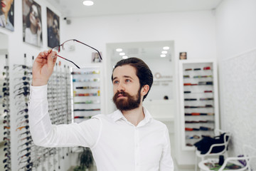 Fototapeta premium Man in a glasses. Guy in a optics shop