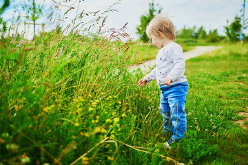 Adorable baby girl walking on field