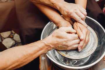 Potter make a small jug. Hands of a potter at work