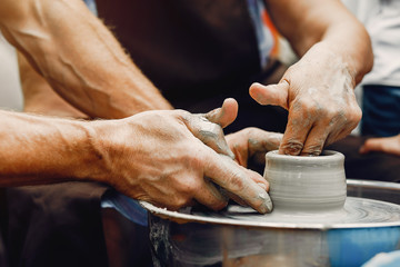 Potter make a small jug. Hands of a potter at work
