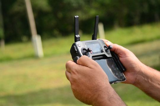 M&atilde;os segurando controle remoto de drone