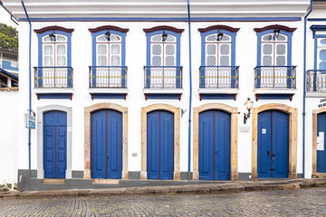 Fototapeta na wymiar Vibrant blue and yellow colour scheme on the facade of a typical historic colonial facade in the city centre of Ouro Preto
