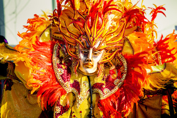 closeup person in flamboyant costume poses for photo at dominican carnival - obrazy, fototapety, plakaty