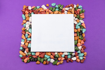 Candy pebbles. sweets in the form of colored stones. frame made from colorful candies with a white space in the center