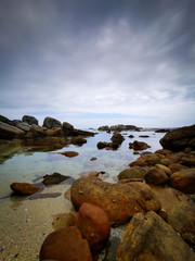 Beautiful sky over ocean water with rocks