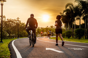 Lover ride on bike and run on the road in the park.