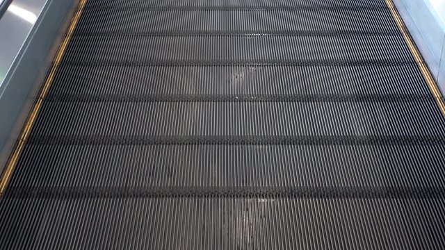 Moving walkway, moving sidewalk, moving pavement, travelator, horizontal escalator, moveator, or auto walk at an international airport terminal, in modern office centre
