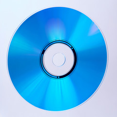 A closeup of a blue compact disc with a white background