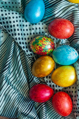 Colorful Easter eggs and silk textile material. Festive Easter holiday concept. View from above. Copy space. Top view