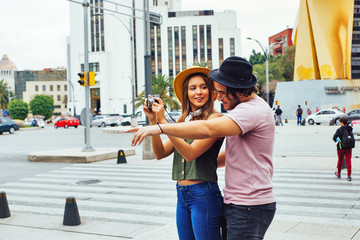 Portrait of a young couple traveling and taking a photo on street of Mexico City center