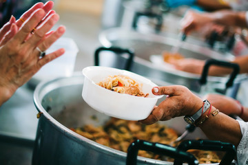 Volunteers are sharing food to needy hungry people.