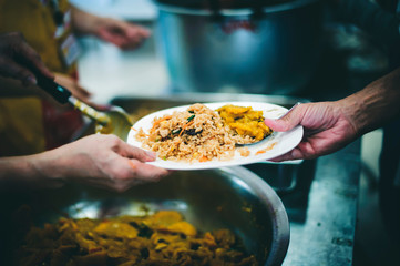 Volunteers are sharing food to needy hungry people.