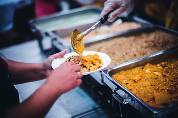 Volunteers are sharing food to needy hungry people.