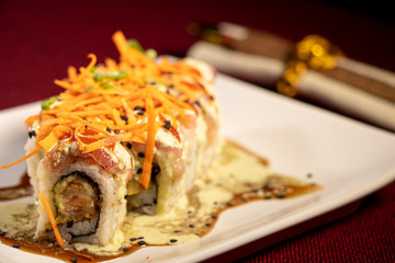 Sushi con camarón empanizado dentro y salmón con zanahoria rallada 