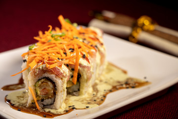 Sushi con camarón empanizado dentro y salmón con zanahoria rallada 