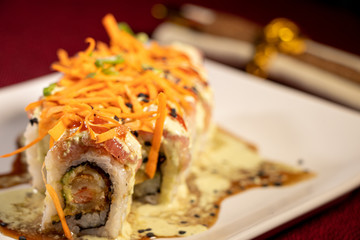 Sushi con camarón empanizado dentro y salmón con zanahoria rallada 