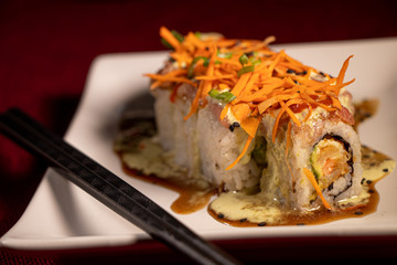 Sushi con camarón empanizado dentro y salmón con zanahoria rallada 