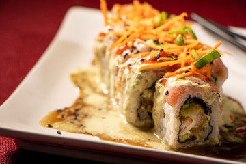 Sushi con camarón empanizado dentro y salmón con zanahoria rallada 