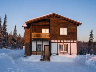 Alpine-style hotel house in the Gornaya Salanga ski resort. The sun rises. Beautiful morning lighting