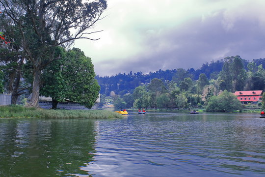 tourists are enjoying boating on kodaikanal lake or kodai lake, in a cloudy morning at kodaikanal hill station, tamilnadu in india