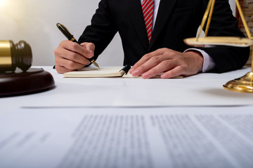 lawyer Detail of a judge sitting at his desk, studying new laws and legislation and taking notes.