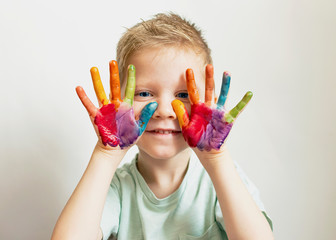 The child paints. Palms and hands of a child in multi-colored watercolor. Watercolor, gouache,...