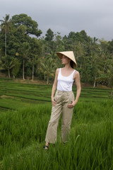 Woman wearing traditionl bamboo hat on the rice field terrace	