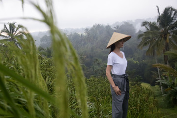 Woman wearing traditionl bamboo hat on the rice field terrace	