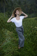 Naklejka na ściany i meble Woman wearing traditionl bamboo hat on the rice field terrace 