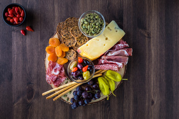 Charcuterie board arrangement of Italian meats, cheese and finger foods.