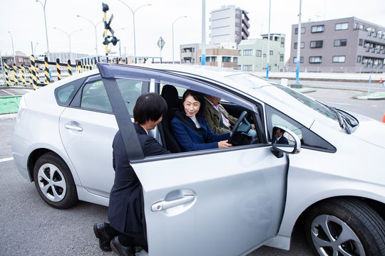 試験管にアドバイスを受ける女性ドライバー