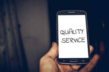 Quality service word written in smartphone