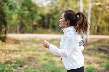 A young beautiful asian woman jogging in city park in the morning