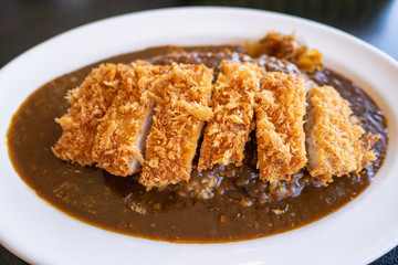 白いお皿に盛った、豚肉を使ったカツカレー。