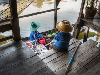 Old woman rowing agricultural products in Khlong Damnoen Saduak at Ban Lak Ha Floating Market