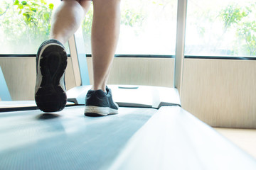Close-up of the runner's shoes has muscles running on the treadmill and exercising at the gym. Health care concept