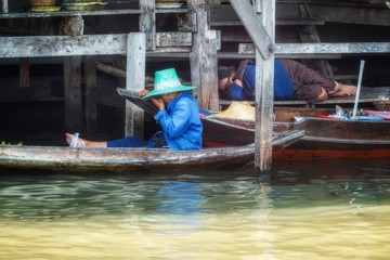 Fototapeta na wymiar Old woman rowing agricultural products in Khlong Damnoen Saduak at Ban Lak Ha Floating Market