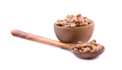 Pinto beans in wooden spoon and wooden bowl an isolated on white background