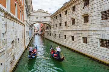 Fototapeta na wymiar Venice, Italy - CIRCA 2013: Bridge of Sighs on top of a small canal (Rio del Palazzo) in Venice, Italy. Two gondolas with tourists 