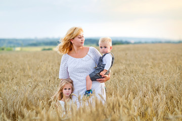 young woman, boy and girl in a wheat field