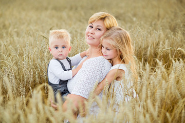 young woman, boy and girl in a wheat field