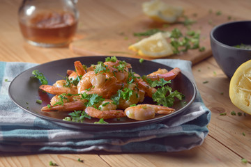 shrimp in a black plate with lemon and green onions