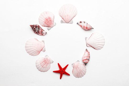 Summer holiday poster with Living Coral color sea shells and starfish on white background, copy space. Top view travel or vacation concept. Flat lay